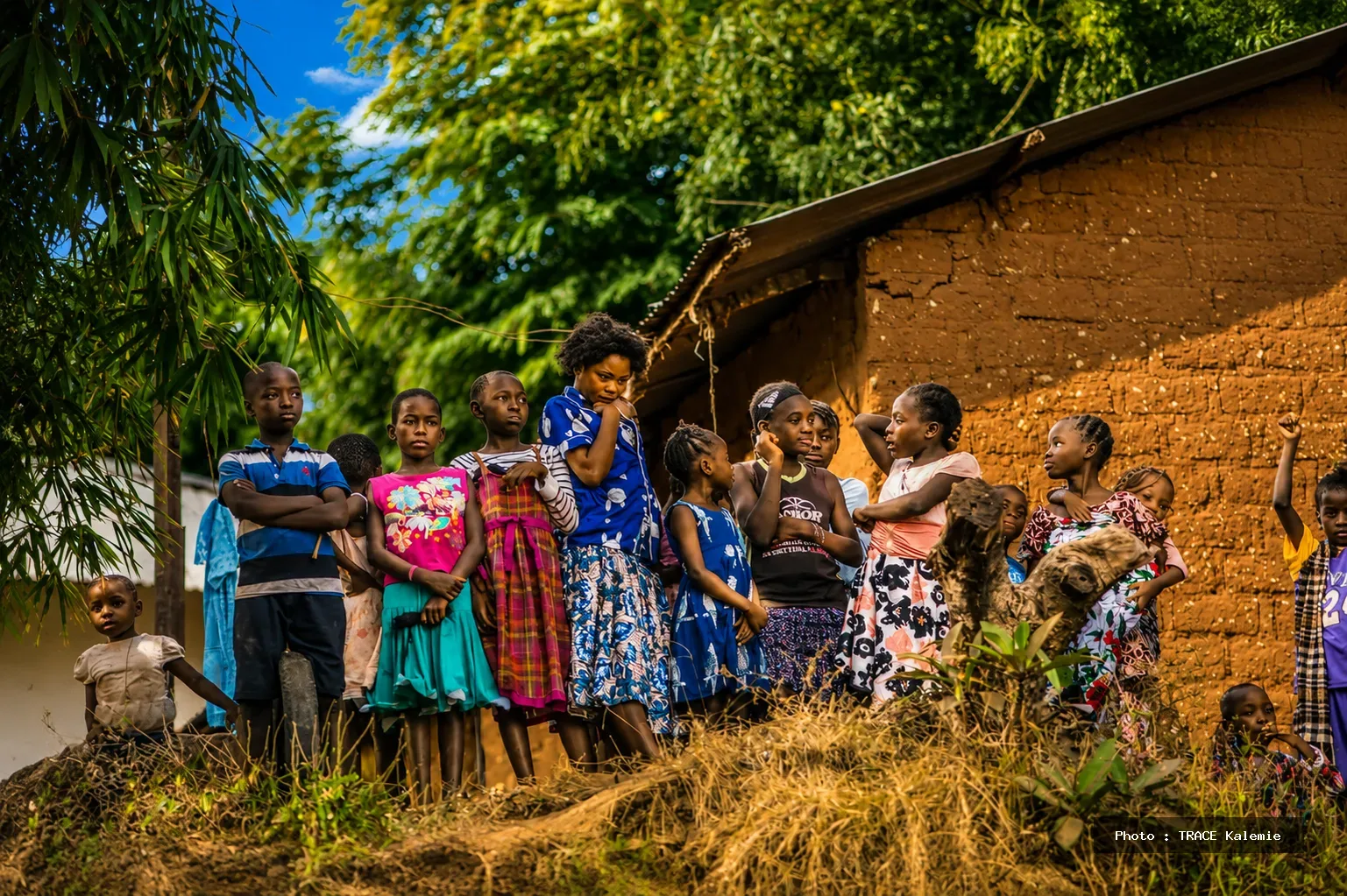 Des enfants rassemblés dans un quartier populaire illustrant les défis de la scolarisation dans certaines zones urbaines du Tanganyika.
